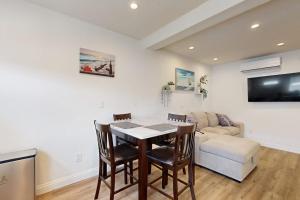 a living room with a table and chairs and a couch at Fair Weather in Newport Beach