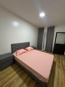 a bedroom with a pink bed and a flat screen tv at Casa da Tá in Espargos
