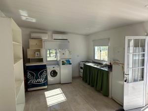 a kitchen with a refrigerator and a washer and dryer at Finca Luz in Santiago del Estero