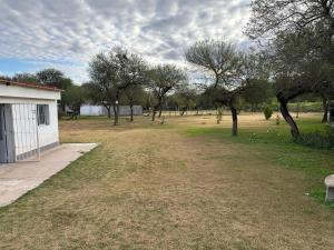 a yard with trees and a building and a field at Finca Luz in Santiago del Estero