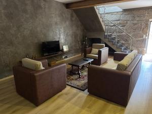 a living room with two couches and a tv at Casas do Monte in Resende