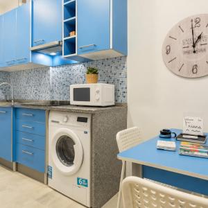 a kitchen with a washing machine and a clock at A Casa do Jamor in Cruz Quebrada