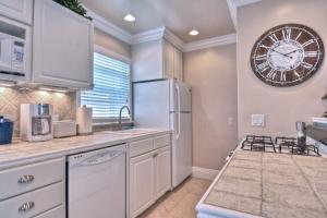 a kitchen with a refrigerator and a clock on the wall at San Clemente - Monterey B in San Clemente