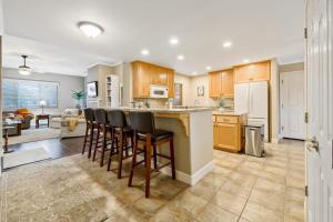 a kitchen with wooden cabinets and bar stools at Berry House in Arroyo Grande
