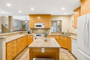 a kitchen with wooden cabinets and a white refrigerator at Berry House in Arroyo Grande +35 photos