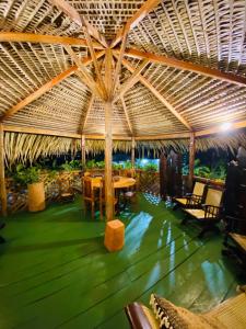 a restaurant with a table and chairs under a straw roof at Casa Quietude - Manaus - Manacapuru in Manacapuru