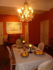comedor con mesa y lámpara de araña en Chambre d'Hôtes Les Augustins - Parking sécurisé - Borne de recharge en Huy