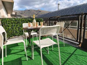a table and chairs on a balcony with green grass at Snow Dreams in Sierra Nevada +6 photos