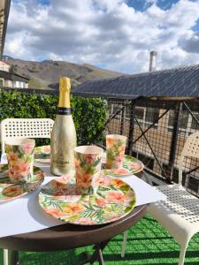 a table with plates and a bottle of champagne at Snow Dreams in Sierra Nevada