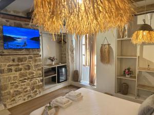 a room with a table and a tv on the wall at Casa Palma Suites in Vlorë