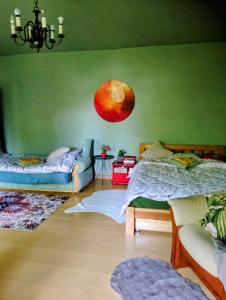 a bedroom with two beds and a moon on the wall at Pod lasem in Górowo Iławeckie