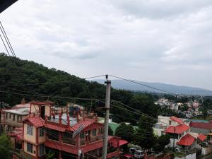 a view of a city with houses and a mountain at Hi Hostels Shillong in Shillong