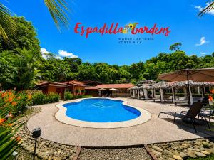 a swimming pool in the middle of a yard at Hotel Espadilla Gardens in Quepos