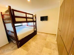 a bedroom with two bunk beds and a television at Departamento en el malecón, Torre Central 102 in Mazatlán +54 photos