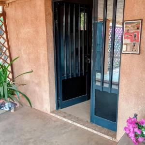 a blue door of a house with some flowers at VILLA Alia in Nianing +9 photos