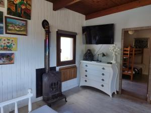 a living room with a wood stove and a tv at Casa a pié de playa de Cariño Doniños in Ferrol