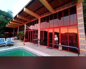 a woman standing in front of a building with a pool at Mar en Casa - Taganga - Vista al Mar in Taganga