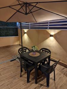 a black table with chairs and an umbrella at Casa vacanze Carmen House in Ercolano