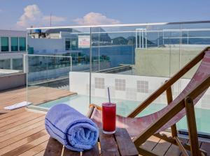 a drink and a towel sitting on a table on a balcony at Rio Design Copacabana Hotel in Rio de Janeiro