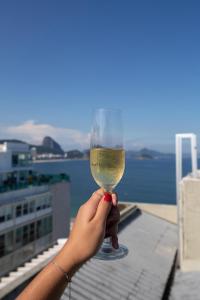 a person holding up a glass of wine at Rio Design Copacabana Hotel in Rio de Janeiro