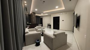a living room with couches and a flat screen tv at Mirada Purple Najran Hotel in Najran