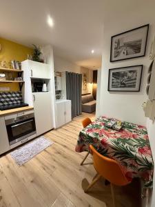a kitchen and a living room with a table in a room at Le cœur du Panier in Marseille