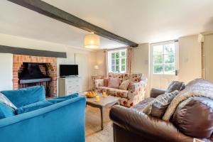 a living room with blue furniture and a fireplace at 3 Bed in Dunwich oc-atc2 in Dunwich