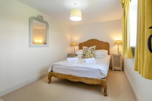 a bedroom with a bed with white sheets and a mirror at 3 Bed in Dunwich oc-atc2 in Dunwich