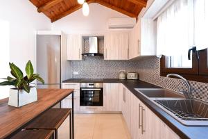 a kitchen with wooden cabinets and a sink at Villa Emerald Diamond in Kolios