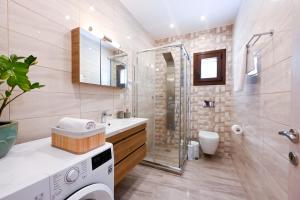 a bathroom with a shower and a washing machine at Villa Emerald Diamond in Kolios +36 photos