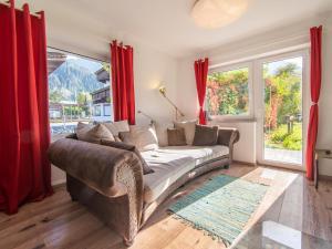 a living room with a couch and red curtains at Regenbogenhaus in Mayrhofen