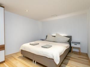 a bedroom with a bed with white walls and a table at Litzlhof Kraftplatzl in Itter