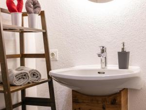 a bathroom with a sink and a shelf with towels at Litzlhof Kraftplatzl in Itter +12 photos