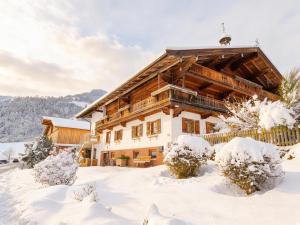 a log cabin in the snow with snow covered trees at Litzlhof Kraftplatzl in Itter