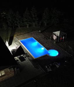 a blue pool on top of a roof at night at Villa Noir Sarajevo in Sarajevo