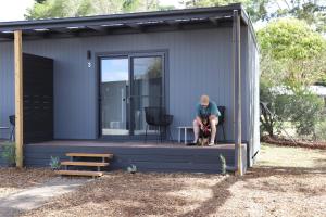 a person sitting on the porch of a tiny house at Lake Colac Holiday Park in Colac