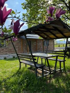 a picnic table and bench under a tree at Villa Noir Sarajevo in Sarajevo