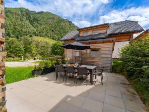 a patio with a table and chairs and a house at Steier Hütte in Donnersbachwald