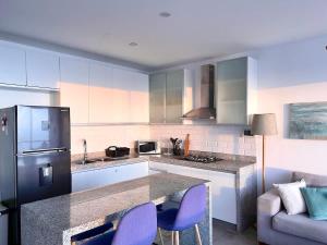 a kitchen with a counter with purple chairs in it at Beach view apartment Punta Hermosa 4BR in Punta Hermosa