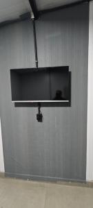 a flat screen tv hanging on a gray wall at City suítes hotel in Diamantino