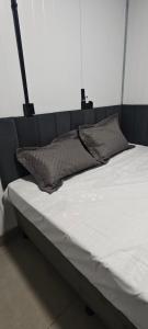 a bed with two pillows on top of it at City suítes hotel in Diamantino