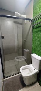 a bathroom with a toilet and a glass shower at City suítes hotel in Diamantino