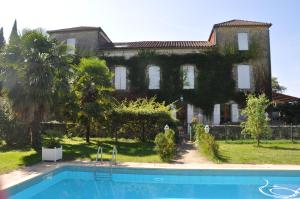 a large house with a swimming pool in front of it at Domaine de Paguy in Betbezer