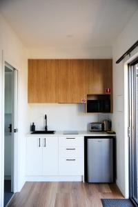 a kitchen with white counters and wooden cabinets at Lake Colac Holiday Park in Colac