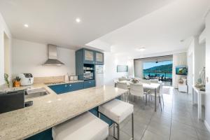 a kitchen and dining room with a view of the ocean at Club Airlie in Airlie Beach