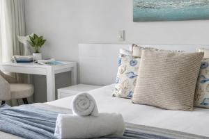 a bedroom with a bed with a towel on it at Club Airlie in Airlie Beach +13 photos