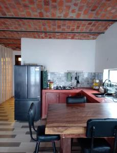 a kitchen with a wooden table and a refrigerator at Off-grid mountain house with a view La Manchoza in Tapalpa