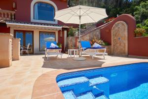 ポルト・ダンドラッチにあるLas Escaleras - Villa SIKA - 4Pの家の隣に椅子2脚とパラソル1本付きのプールがあります。