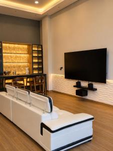 a living room with a white couch and a flat screen tv at Reserva Itay in Luque