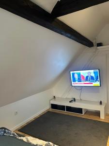 a living room with a tv on a white wall at Alsacian home in Eckbolsheim